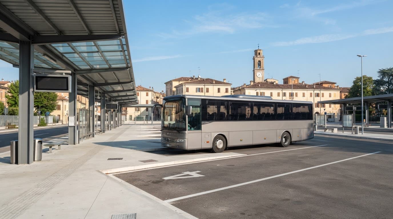 Autobus regionale moderno fermo in una stazione italiana soleggiata.