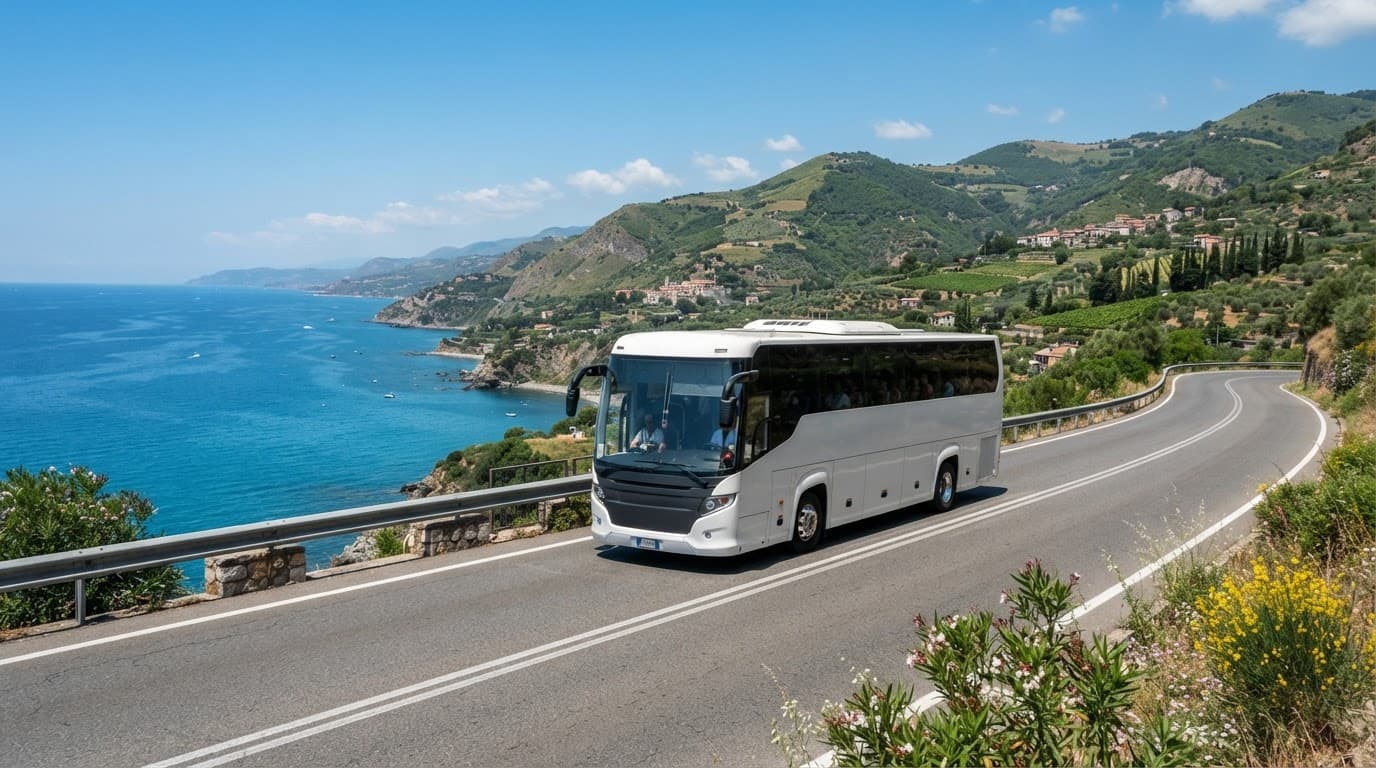 Un autobus moderno percorre una strada soleggiata tra le colline verdi della Calabria.